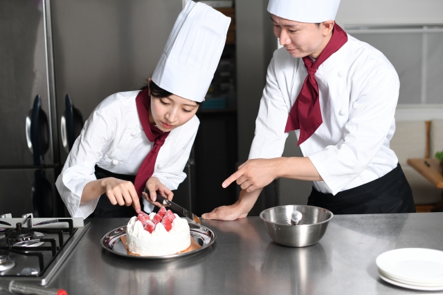 男女二人のパティシエが、ケーキを作っている様子。